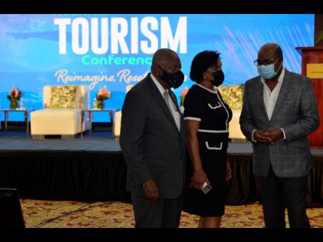 Minister of Tourism Edmund Bartlett (right), speaks with chairman of the Tourism Enhancement Fund, Godfrey Dyer and executive director of Jamaica Vacations, Joy Roberts, at the opening of the Jamaica Health and Wellness Conference on November 18, at the Montego Bay Convention Centre, St James.
